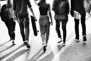 Teenagers walking away in a group. They may benefit from child and teen counseling from SoundWell Music Therapy.