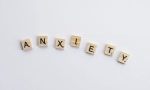 Letter tiles spelling out the word "anxiety." Playing games is one way of managing feelings of anxiety.
